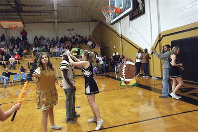 Image: Senior Gladiator Marvin Cox(3) gets blindfold by cheerleader Taylor Turner and then handed a battering stick by mascot Reagan Adams in which to further damage the Stamford piñata.