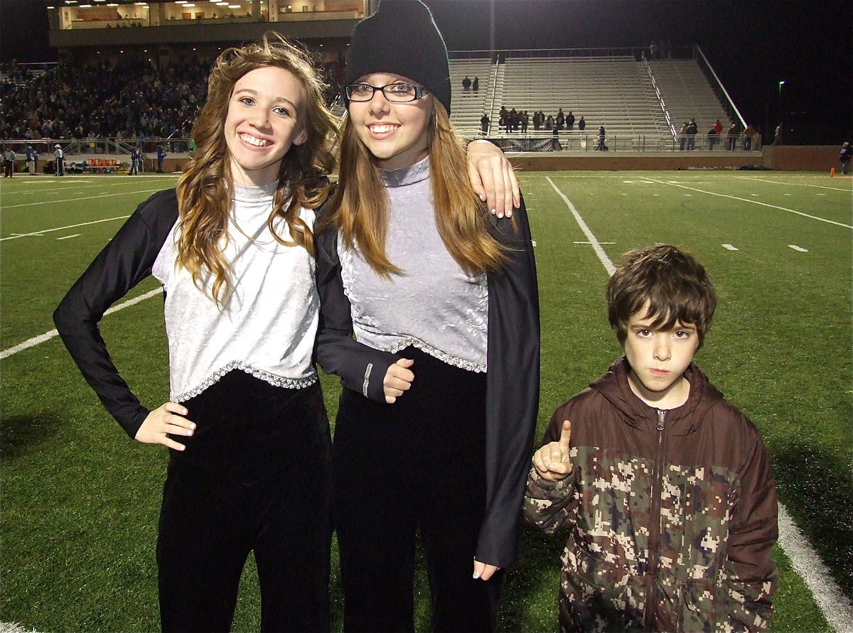 Image: Color guard members Brooke Miller and Anna Riddle and IYAA Gladiator Dustyn Rose join in the pre-game spirit line.