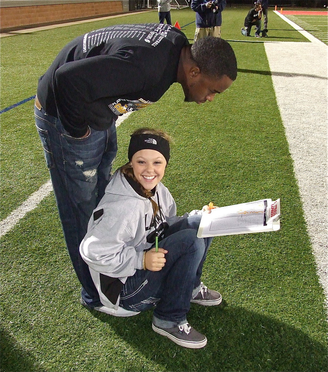 Image: Stat keeper Bailey Eubank finds a way to relax and stay dry while Jasenio Anderson peers at the numbers.