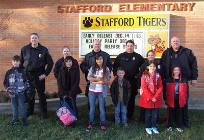 Image: Italy Police Officers pick up Stafford Elementary students in their sleigh-like squad cars Tuesday, December 11, and take the students to “Shop with a Cop” for themselves and their families for Christmas. Pictured (L-R) are: Officer Mike Richardson with Mitchell Darell, Officer Shelbi Landon with Arley Salazar, Officer Shawn Martin with Julliette Salazar, Officer Eric Tolliver with Chance Shaffer, Sergeant Tierra Mooney with Farrah Eglich and Chief Diron Hill with Christopher Cryer.