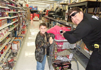 Image: Officer Eric Tolliver and Chance Shaffer go down the furniture isle incognito in camo and shades as if they’re on a secret Santa mission.