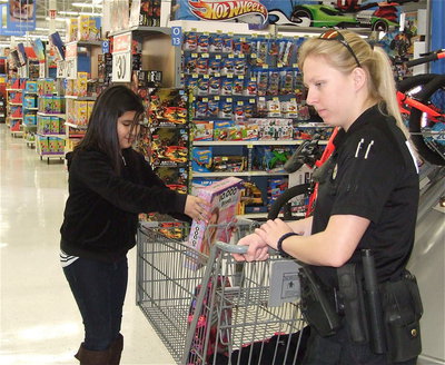 Image: Arley Salazar picks out a puzzle while Officer Shelbi Landon surveys the scene.