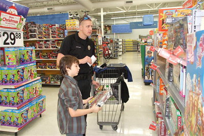 Image: Officer Mike Richardson is on standby as Mitchell Darell scrutinizes his purchases.