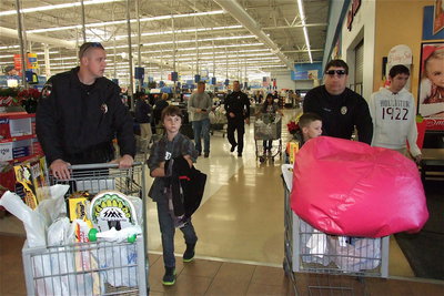 Image: Officer Mike Richardson, Mitchell Darell, Chance Shaffer and Officer Eric Tolliver are armed and loaded with Christmas presents.