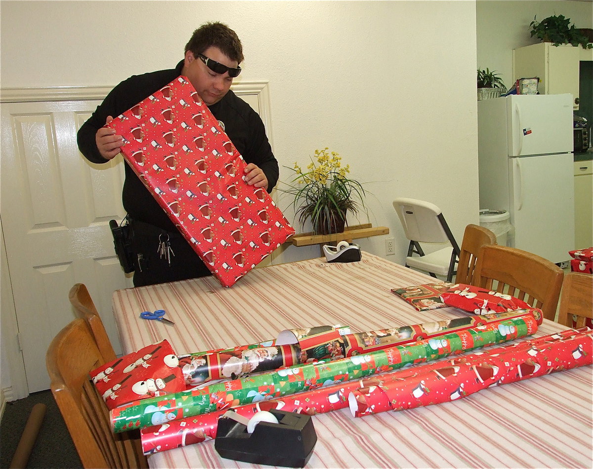 Image: I fold this thingy here, put this tape stuff there and, “Whala!” Hopefully this package wrapped by Officer Eric Tolliver will not come open until Christmas.