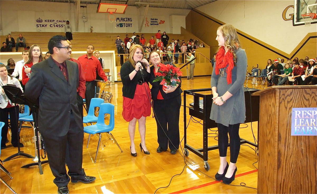 Image: Band director Jesus Perez looks on as drum major Emily Stiles and assistant drum major Madison Washington present assistant band director Erica Miller with a bouquet of flowers for her efforts towards the band this year.