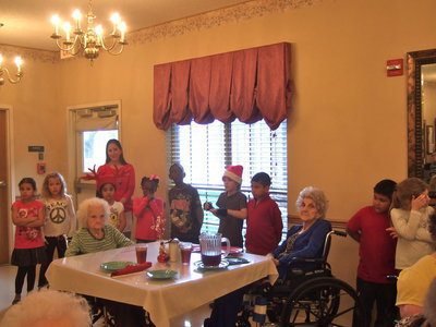 Image: Residents being sung to while they wait for their noon meal.