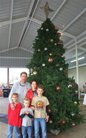 Image: Charles Hyles and his family stand next to the Christmas tree on display under the newly erected downtown pavilion. Charles played a major part in in bringing the pavilion project from concept to Christmas Festival.