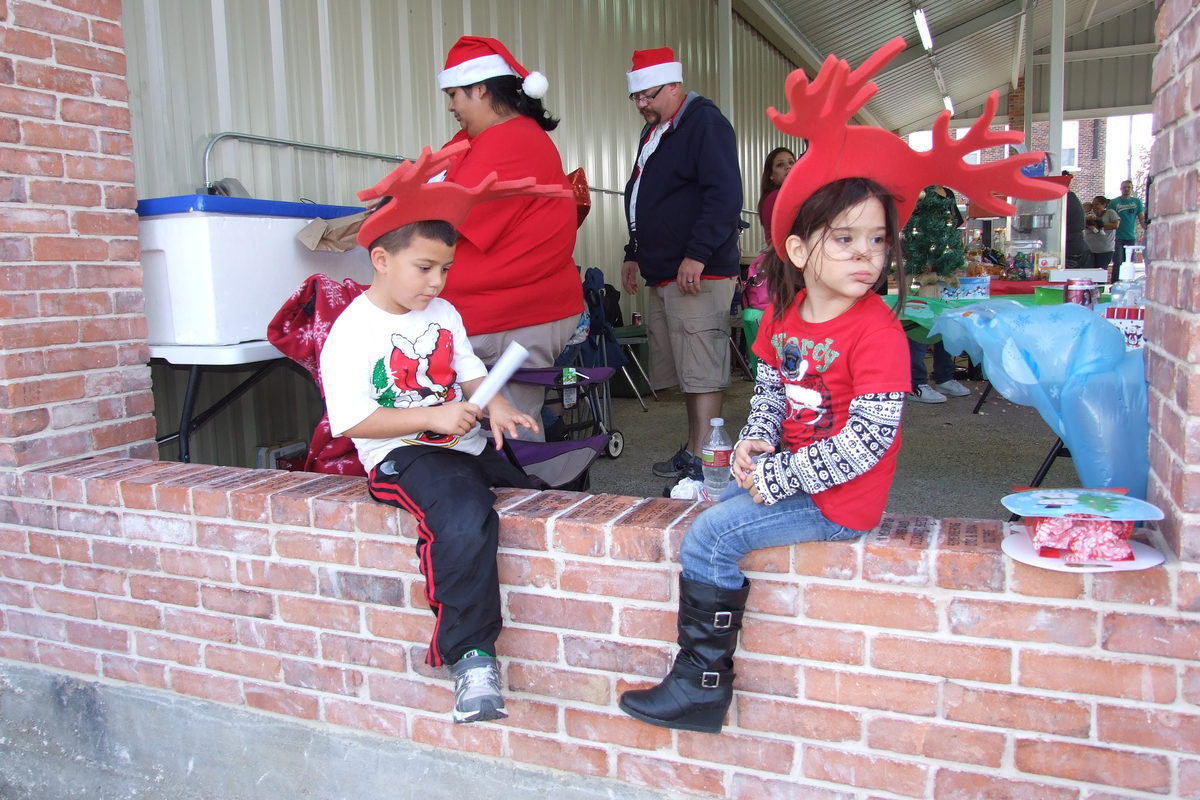 Image: With booths one-after-another throughout the interior of the pavilion, festival goers relax on a pony wall that is lain with personalized brick placeholders.