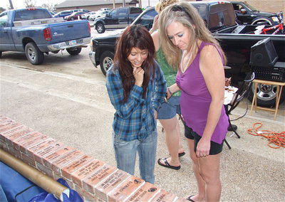 Image: Festival goers peruse the brick placeholders lining the pavilion’s pony walls.