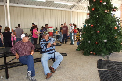 Image: Lucio Jacinto and Pablo Jacinto relax on picnic tables next to the Christmas tree inside the pavilion.