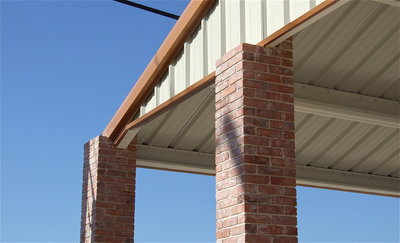 Image: Where the brick columns meet the metal roof located in the rear left corner.