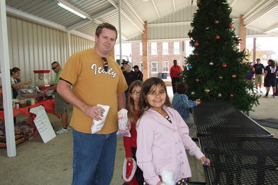 Image: Mike South, with Monolithic Constructors, Inc. of Italy, and his daughters Evie and Catie and his son Mikey, who is admiring the Christmas tree, take in the 2012 Christmas Festival and Parade while enjoying the new pavilion.
