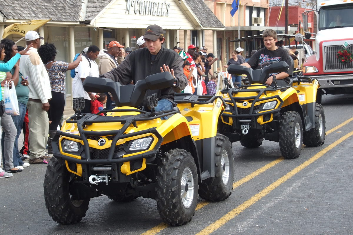 Image: Brothers Russell and Wesley Helms sport matching four-wheelers while parents Keith and Peggy Helms follow in a Helms Garage and Wrecker service tow truck.