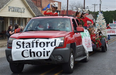 Image: The Stafford Elementary Choir whistles past as Destiny Harris tosses candy to parade watchers.