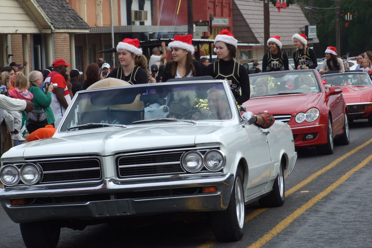 Image: Jimmy Hyles, Bobbie Hyles and Ronnie Hyles form a convertible caravan to usher the Italy High School cheerleaders down the parade route.