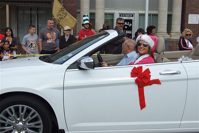 Image: Deonna Padila with Bling-n-Blooms of Italy transports business neighbor Bobby Harris along the parade route.