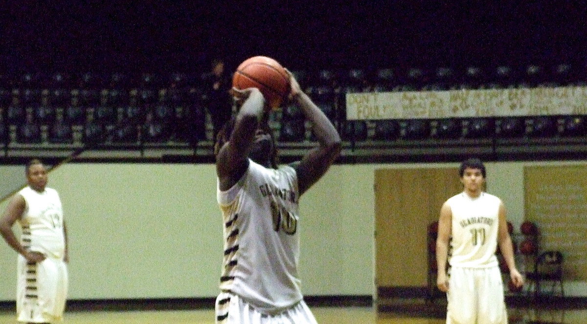 Image: Darol Mayberry(13) and Tyler Anderson(11) observe Ryheem Walker(10) shooting a free-throw attempt.