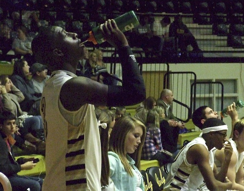 Image: Italy’s senior point guard Marvin Cox(3) hydrates during a break while checking the scoreboard.