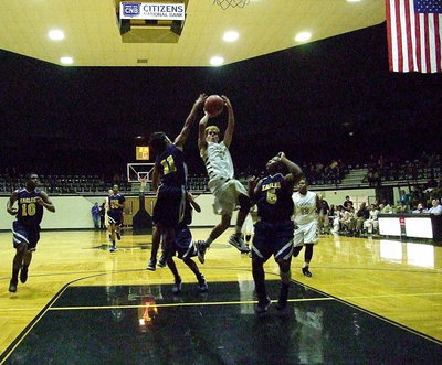 Image: Gladiator Kelvin Joffre(14) splits a pair of Eagle defenders on his way to the basket.