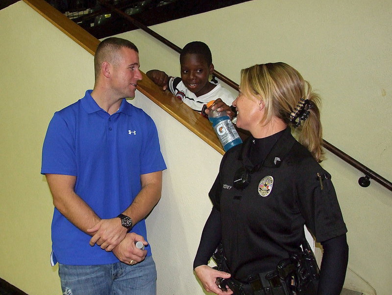 Image: Bryan P.D.‘s Officer Bobby McFarland and Italy P.D.’s Sergeant Tierra Mooney visit with Byron Davis during the games between Italy and Grand Prairie Advantage Academy.