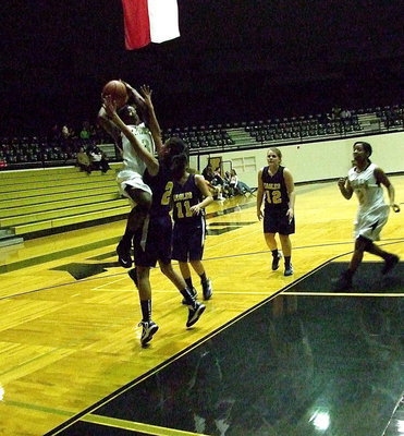 Image: Somehow, Kortnei Johnson(3) gets this shot to go with a Lady Eagle defender playing tight defense.
