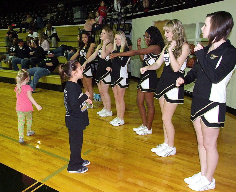 Image: The IHS cheerleaders Ashlyn Jacinto, Taylor Turner, Britney Chambers, K’Breona Davis, Kelsey Nelson and Meagan Hooker get help from Ella and Hannah.