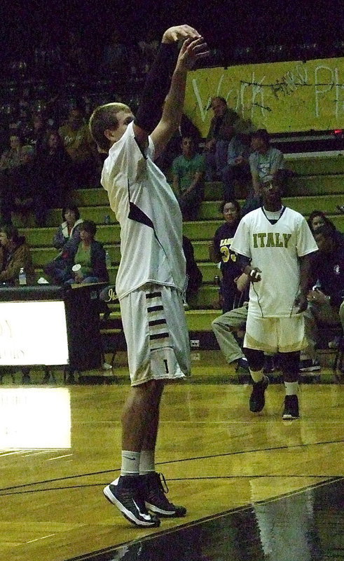 Image: Gladiator Cole Hopkins practices free-throws before the game while teammate Marvin Cox works on his jump shot.