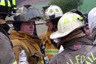 Image: Former Italy Gladiator football star Jackie Cate, a longtime volunteer with the Italy Fire Department, huddles with fire crews during a break in the action.