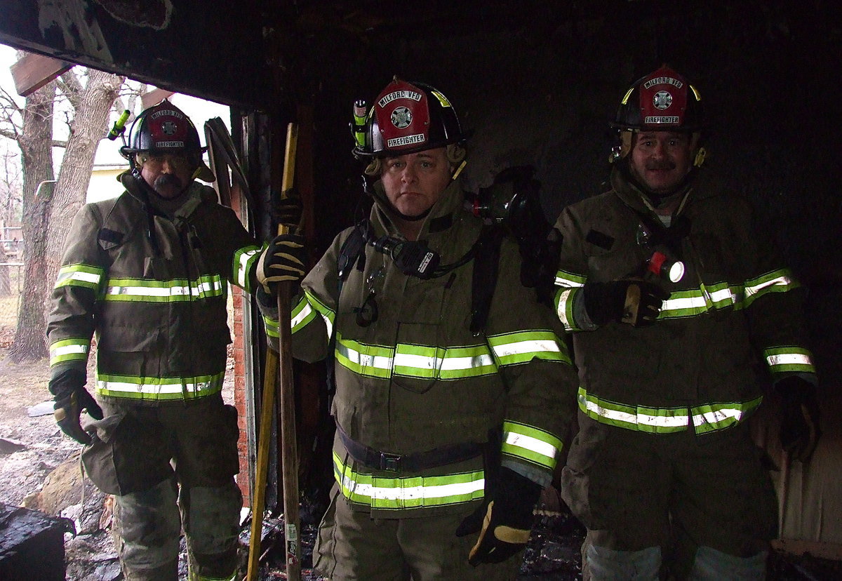 Image: Milford firefighters wait for the command to tear down a wall.