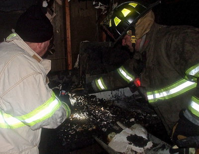 Image: Italy Firefighter Donald Chambers and Milford Firefighter Carlos Phoenix clear debris during their investigation.