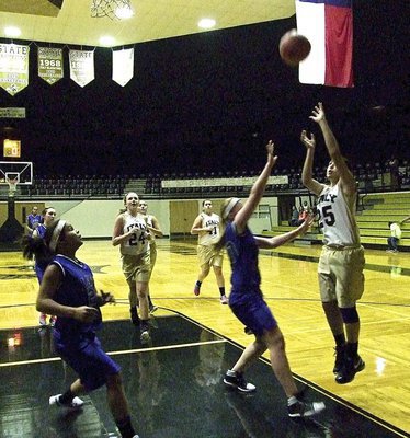 Image: Elizabeth Garcia(25) puts up a shot as teammate Annie Perry(24) hustles in for the board.