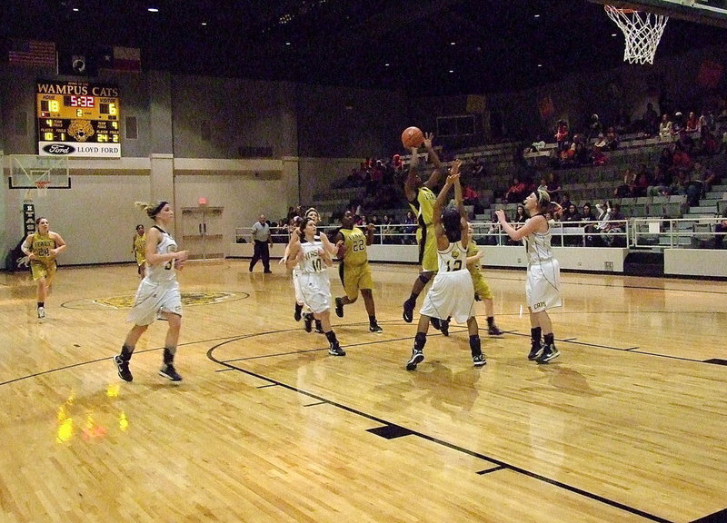 Image: Kortnei Johnson(3) puts up a shot as Taleyia Wilson(22) and Tara Wallis(4) get down the court to rebound.