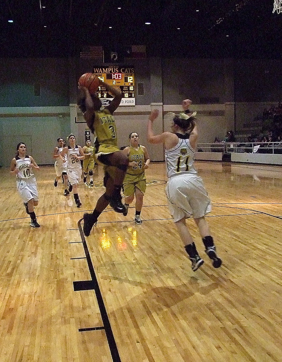 Image: Kortnei Johnson(3) gains altitude as teammate Alyssa Richards(24) sprints down to help rebound.