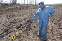 Image: Local activist Elmerine Bell points out potential graves that have been marked after a dowsing rod was used to define their location. Many headstones located at Hughes Cemetery, between Italy and Avalon, have been flattened by bulldozers belonging to Creek Land and Cattle Company, a land development business registered in the State of Nevada.