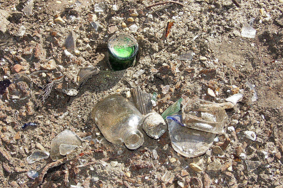 Image: A closer view of the broken bottles, pottery and dishes that were once set upon headstones at Hughes Cemetery, headstones now smashed and hoped to be forgotten.