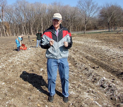 Image: Rex Carey with the Ellis County Historical Commission uses brass dowsing rods to locate possible graves underground after the headstones had been illegally demolished by Creek Land and Cattle Company’s bulldozers. In this photo, the rods criss-cross as Carey approaches another potential unmarked grave.