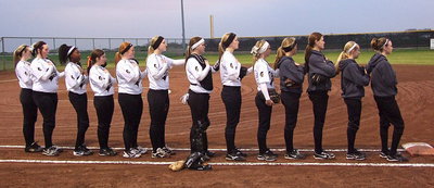 Image: The Lady Gladiators showing respect to the American flag.