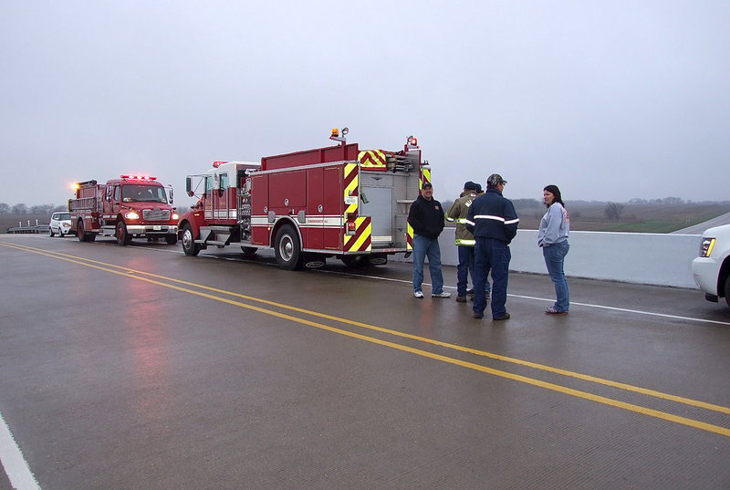 Image: The Italy and Milford Fire Departments join forces to honor fallen war hero Chris Kyle in anticipation of his funeral procession traveling along Highway 35 headed for Austin. Both Departments, along with community members, waited in the drizzle for more than an hour before the first police cars and motorcycles leading the procession began passing under the Dale Acres overpass around 9:30 a.m.