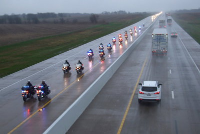 Image: Police vehicles and motorcycles lead the Chris Kyle procession.