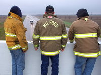 Image: Italy Firefighter Brad Chambers, Milford Firefighter Andy Frank and Italy Firefighter Paul Cockerham observe the Chris Kyle funeral procession from the Dale Acres overpass.