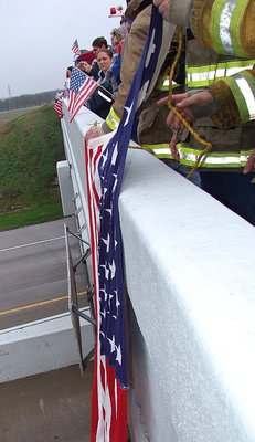 Image: American flags wave from the overpass in tribute to Chris Kyle, as was the scene from one town to another, as his funeral procession made the journey to Austin.