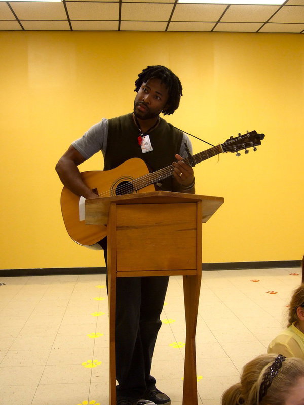 Image: Erskin Anabitarte works with the CBI students and also plays his guitar along with the choir.
