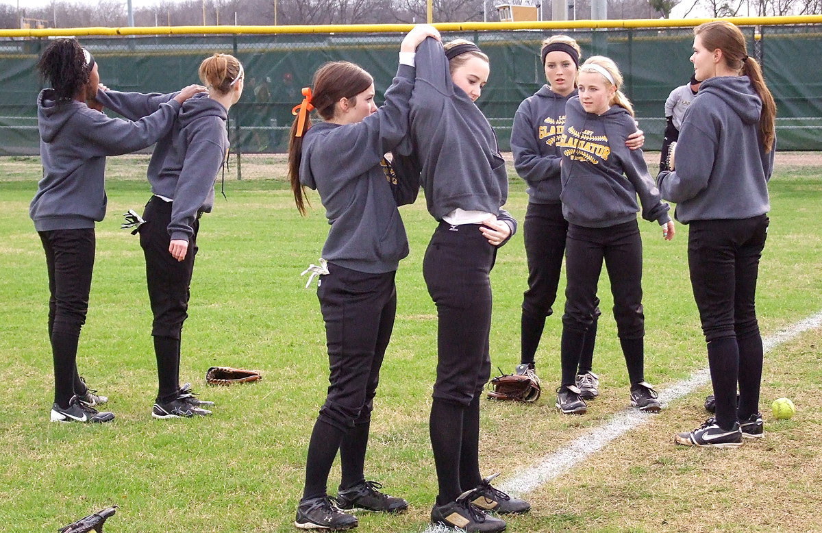 Image: That’s the spot: Team members assist one another during pre game stretches.