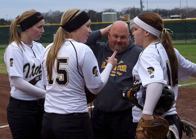 Image: Head softball coach Wayne Rowe gets a kick out of strategizing with his players as Madison Washington, Jaclynn Lewis and Paige Westbrook figure it out.