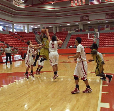 Image: Gladiator Marvin Cox(3) bullies his way into the lane to shoot as Ryheem Walker(10) hustles in to rebound.