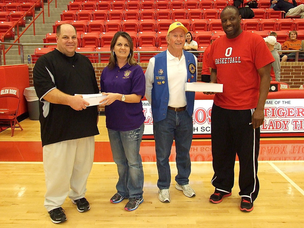 Image: Italy’s head basketball coach Brian Coffman is presented a gift and a coupon, along with Olney’s head coach J.D. Sullian, after the game in appreciation from the Lions Club International, one of the tournament hosts.