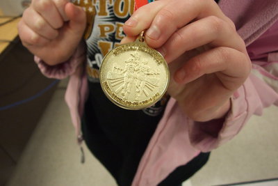 Image: Katie Connor displays the backside of her Special Olympics medal.
