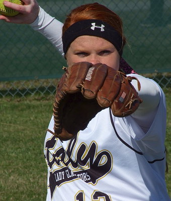 Image: Third baseman Katie Byers uses her glove as a gun sight as she practices on her firing range.