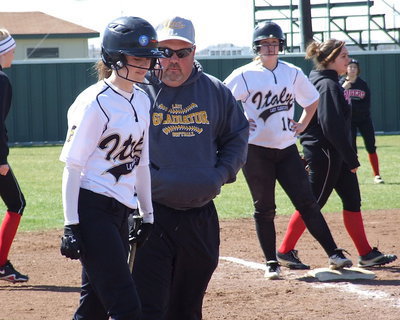 Image: Lady Gladiator Softball head coach Wayne Rowe confers with sophomore Kelsey Nelson as teammate Paige Westbrook(10) stands at third base. Nelson went on to get a hit scoring Westbrook.